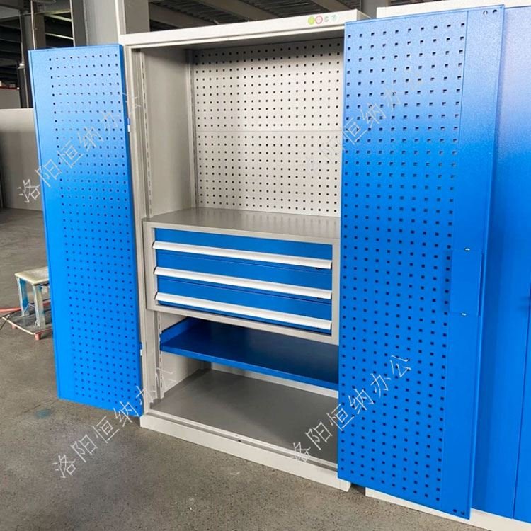 Heavy-duty steel tool cabinet with pegboard doors and drawer unit in a factory workshop